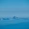 Distant view of Capri island silhouetted against blue sky across Gulf of Naples waters, photographed from Mount Vesuvius, Italy