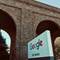 Google San Francisco office sign on white wall beneath large brick archways of converted industrial warehouse building