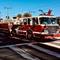 San Francisco Fire Department aerial ladder truck parked on city street with extended ladder apparatus, second fire vehicle visible behind