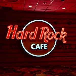 Hard Rock Cafe neon sign with red cursive lettering and white 'CAFE' text in circular design on brick wall in Stateline restaurant